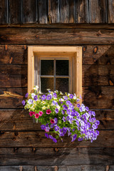 Window of old farmhouse decorated with flowers