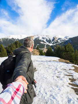 Follow Me. Mature Man Holding Hands And Leading Woman The Beautiful Winter Nature. View From Behind, Pov. Romantic Travel As A Couple, Spend Winter Holidays Together Outdoors.