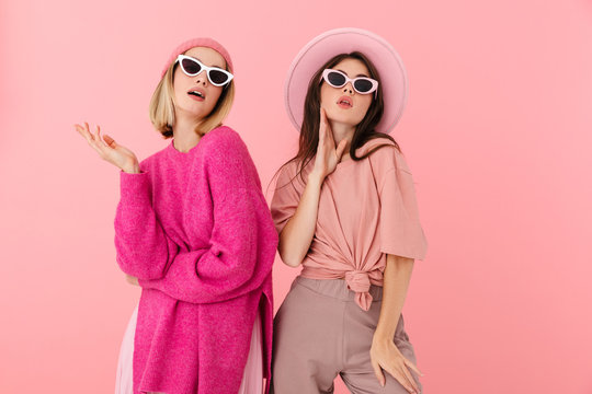 Image of two fashion women posing at camera in stylish sunglasses