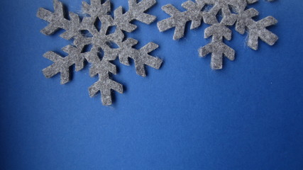  Two grey felt snow stars on a blue background. Flat lay.  Creative Christmas card idea