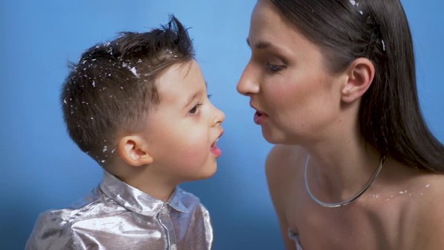 mom in silver dress kisses son in Studio