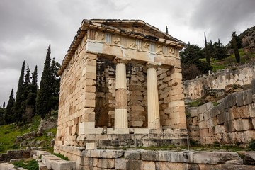 Fototapeta na wymiar The ancient Delphi in Greece with Treasury of Athenians in cloudy weather with perspective view