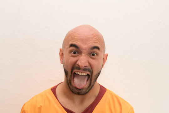 primer plano de calvo sacando la lengua burlandose