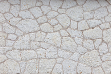 the texture of the wall is made up of pieces of different shapes of natural white stone. White brick wall, background, texture. 