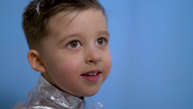 cheerful baby boy in silver holiday shirt in Studio