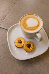 A Cup of hot latte art coffee with cookies