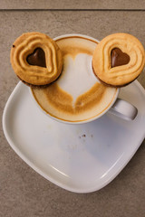 A Cup of hot latte art coffee with cookies