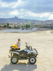 Asian girl making up bags by an ATV in Cappadocia's valley