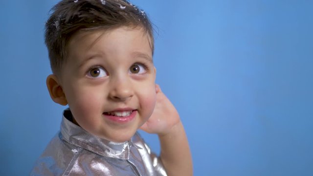 cheerful baby boy in silver holiday shirt in Studio