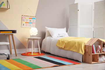 Fototapeta na wymiar Stylish child room interior with comfortable bed and desk