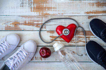Healthy,  Healthcare concept , diet plan with sport shoes , apple, water bottle and  stethoscope.on dark wooden background