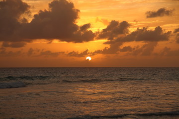 Beautiful crimson red sunset from the beach over the Caribbean Sea in Barbados, Atlantic Ocean