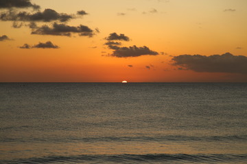 Beautiful crimson red sunset from the beach over the Caribbean Sea in Barbados, Atlantic Ocean