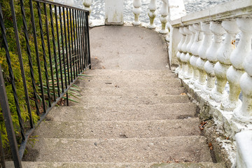 Dirty Cracked Stairs with Black Wrought Iron Railings