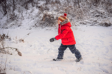 Cute boy in red winter clothes runs fun in the snow. Winter Fun Outdoor Concepts
