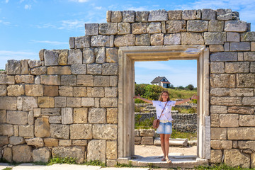 Plakat girl in the stone wall of the ancient city of Chersonese