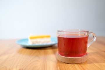 Mousse dessert and fruit tea on a large bright wooden table