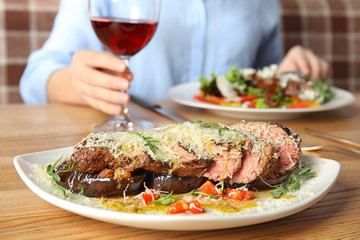 Delicious roasted meat and blurred woman on background