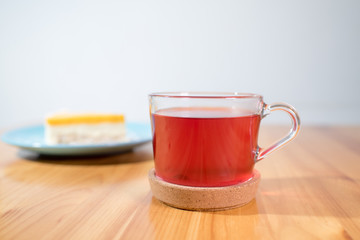 Mousse dessert and fruit tea on a large bright wooden table