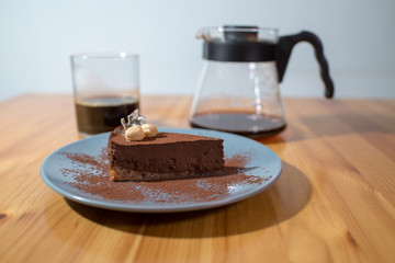 Hario v60 and chocolate cake on a large bright wooden table