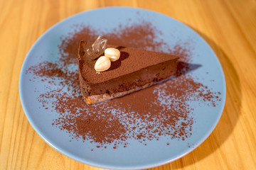 Delicious black chocolate dessert on a large bright wooden table