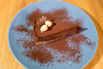 Delicious black chocolate dessert on a large bright wooden table