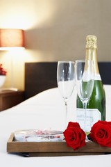 Champagne and flutes on bed