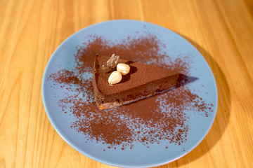 Delicious black chocolate dessert on a large bright wooden table
