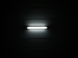 Light bulbs under the ceiling at night, fluorescent light tube on the dark wall, The light illuminating in the black background.