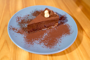 Delicious black chocolate dessert on a large bright wooden table