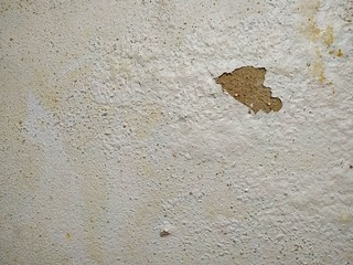 The wall damage and peeling paint because of water leaks, White cement wall with mold texture background.