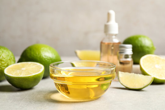 Lime Essential Oil And Cut Citrus Fruits On Light Table