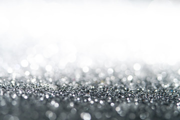 Silver Sparkling Lights Festive background with texture. Abstract Christmas twinkled bright bokeh defocused and Falling stars. Winter Card or invitation	