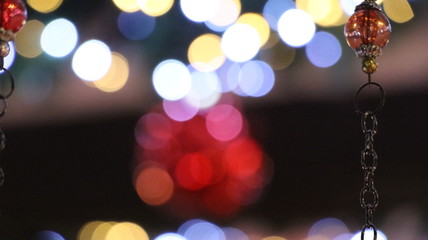 Christmas illuminations with blurred effect. Red & white light sparkle on glitter ornaments. Celebration design. Bright abstract texture. Background colorful holiday night. Blurry xmas festive party. 