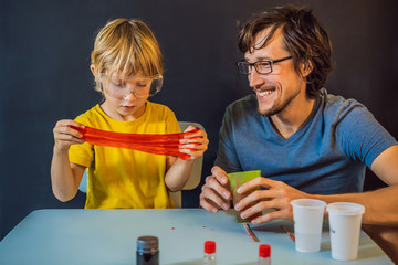 Father and son conduct chemical experiments at home. Home made slime. Family plays with a slime