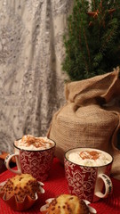 Christmas dish with hot chocolate, coffee, cafe, baked muffin and green fir branch. Red festive seasonal table. Warm drinks, mug filled with beverage. New year holiday sweet breakfast, morning food.