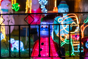 Illuminated Christmas decorations seen through a gate