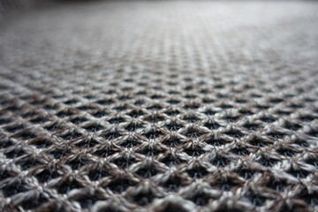 Closeup of brown woolen fabric with diamonds pattern
