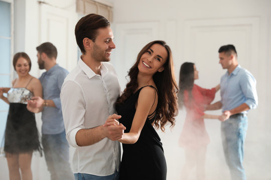 Lovely young couple dancing together at party