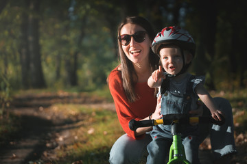 mother and daughter. Balance bike. Cycling in park.