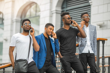 four african men with phones in their hands near the building