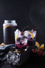 Fresh blueberry cocktail with lemon peel and cherry..