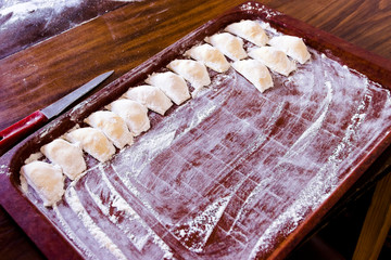 Traditional pelmeni or dumpling at cutting board.