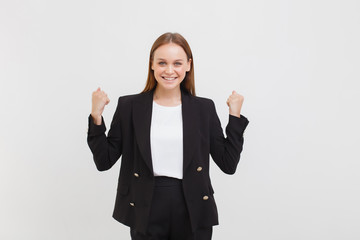 woman in black suit. Girl yelling happiness, clenching fists victory celebrating success smiling broadly close eyes achieve goal, winning, victory good news lucky opportunity, white background