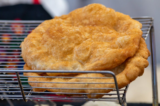 Freshly baked langos offered on the market. Hungarian speciality, a deep fried flat bread made of potato-based dough offered on the market.