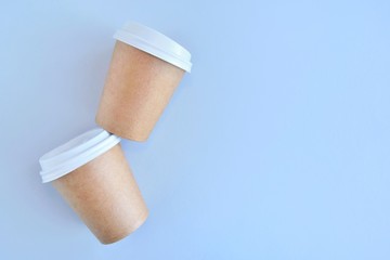 Recycling craft paper cup of coffee to go on neutral background with copy space. Selective focus. Craft cup for hot beverage, takeaway. Disposable cup. Eco package. Cardboard coffee cup