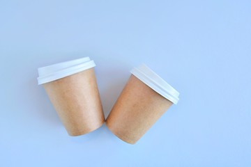 Recycling craft paper cup of coffee to go on neutral background with copy space. Selective focus. Craft cup for hot beverage, takeaway. Disposable cup. Eco package. Cardboard coffee cup