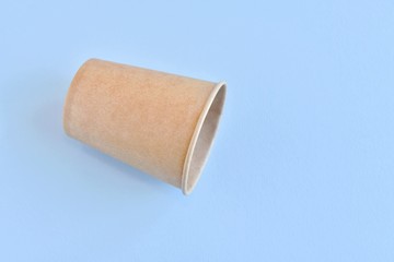 Recycling craft paper cup of coffee to go on neutral background with copy space. Selective focus. Craft cup for hot beverage, takeaway. Disposable cup. Eco package. Cardboard coffee cup