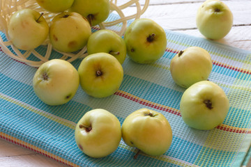 ripe green apples scattered on a white wooden table. juicy apples on the towel. space for text. the view from the top. healthy eating concept