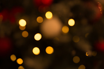 Warm gold bokeh lights of garland balls on Christmas tree. New Year background fairytale atmosphere.